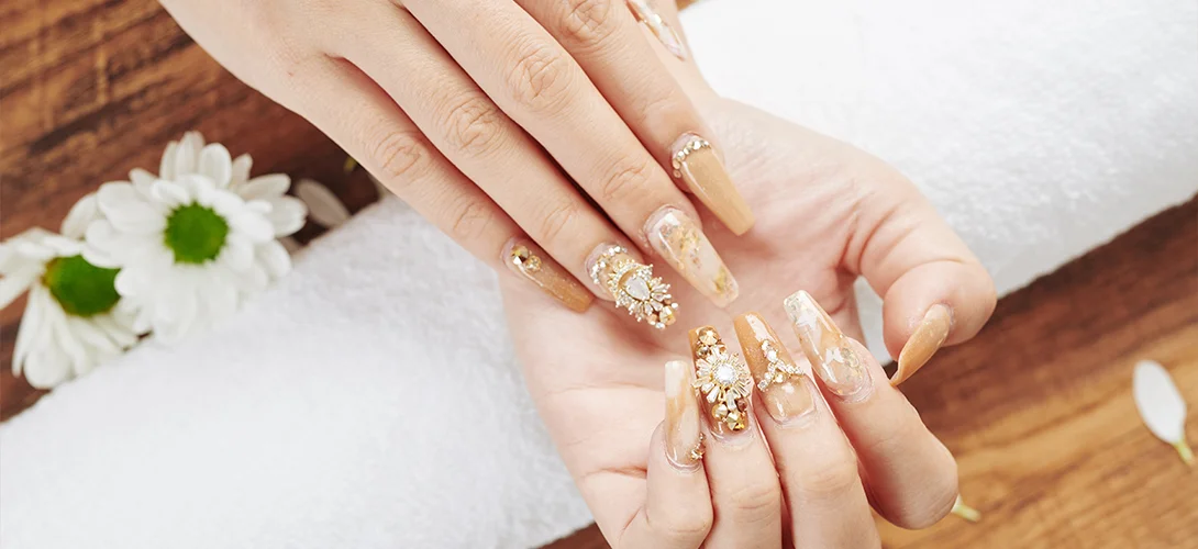 Close-up of a manicured hand with a glossy neutral gel finish resting on a salon table
