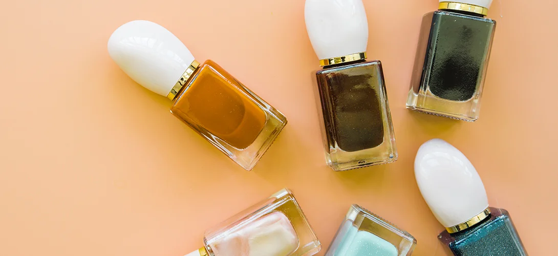 Hands with a fresh set of enhanced nails in a soft neutral finish on a salon towel